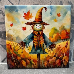 Puede incluir: Una pintura de acuarela de un espantapájaros sonriente de pie en un campo de follaje de otoño. El espantapájaros lleva una camisa azul, una bufanda colorida y un sombrero marrón. El fondo es un campo de hojas amarillas y naranjas.