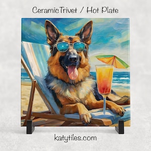 May include: Square ceramic trivet with a German Shepherd in sunglasses, enjoying a cocktail on a beach. The image has a painterly style, with the text "Ceramic Trivet / Hot Plate" and "katytiles.com".