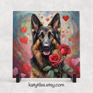 May include: A German Shepherd dog with black and brown fur is surrounded by red hearts and roses. The dog is looking directly at the viewer with a happy expression. The background is a colourful abstract painting.