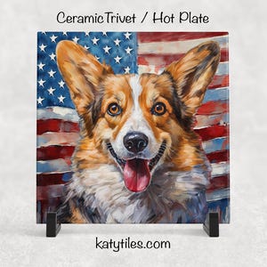 May include: Square ceramic trivet with a corgi illustration against an American flag. The corgi has brown and white fur and a pink tongue. The background features red, white, and blue stripes and stars. The trivet is on a black stand. The text "katytiles.com" is visible.