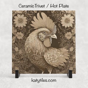 May include: Square ceramic trivet with a sepia-toned rooster illustration. The rooster is the focal point, set against a floral background. The trivet is displayed on a black stand. Text at the top reads "Ceramic Trivet / Hot Plate". The website katytiles.com is at the bottom.