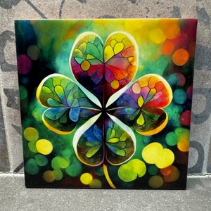 May include: A colorful four-leaf clover with a green, yellow, red, and blue stained glass design on a dark green background with colorful circles.