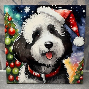 May include: A black and white dog wearing a red Santa hat with a white pom-pom. The dog is in front of a green Christmas tree with red and green ornaments. The background is a blue and white watercolor-style design.