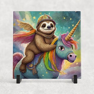 Puede incluir: Un perezoso marrón con un casco azul y dorado monta un unicornio arcoíris con un cuerpo azul y una crin rosa y morada. El fondo es un cielo acuarela azul y verde con estrellas.