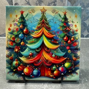 Puede incluir: Un azulejo de cerámica colorido con una ilustración caprichosa de tres árboles de Navidad decorados con adornos y luces. Los árboles están pintados en tonos de verde, azul, rojo, amarillo y naranja, con un estilo caprichoso y de dibujos animados.