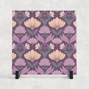 May include: A purple ceramic tile with a repeating pattern of stylised flowers in shades of pink, purple, and teal.