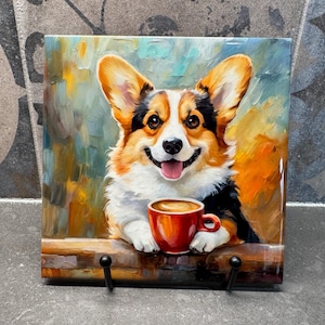 May include: A painting of a corgi dog holding a red coffee mug with a brown liquid inside. The dog is smiling and has a pink tongue sticking out. The background is a colourful abstract painting.
