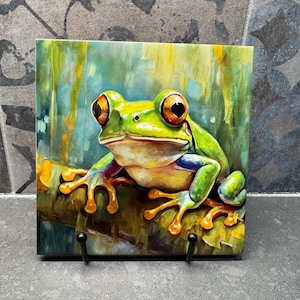 Peut inclure: Une grenouille verte aux yeux orange et aux orteils jaunes est assise sur une branche avec un arrière-plan flou de vert et de jaune.