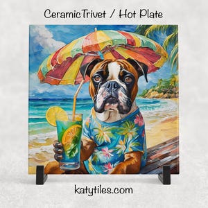 May include: Square ceramic hot plate featuring a Boxer dog on a beach, wearing a Hawaiian shirt and holding a cocktail. The dog is under a colorful umbrella. The background shows a beach scene with palm trees and ocean. Text at the top reads "Ceramic Trivet / Hot Plate".