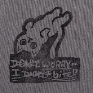 May include: A grey fabric patch featuring a black cartoon cat illustration and the text "DON'T WORRY - I don't bite!" The cat is drawn upside down with large eyes and a playful expression.