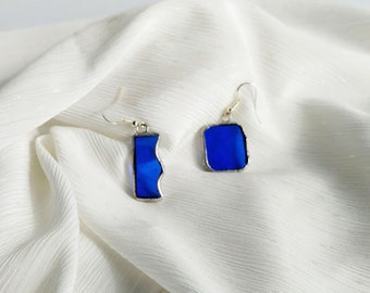 Mismatched earrings, blue translucent glass