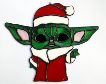 Christmas stained glass ornament. Baby Yoda green disguised as red Santa Claus. Artistic creation, sun catcher inspired by Star Wars "The Mandalorian"