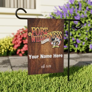May include: A brown wooden garden flag with the text "Fort Wilderness Resort" and a cartoon image of Mickey Mouse. The text "Your Name Here" and "est 2019" are also on the flag.