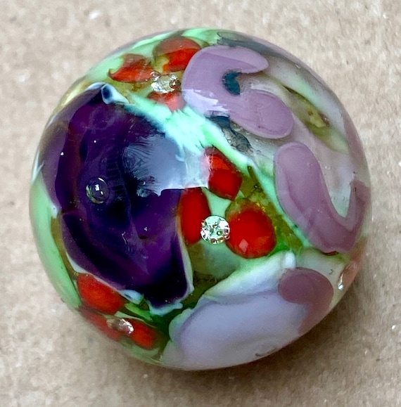 Handmade artisan glass collector's marble with purple & red flowers