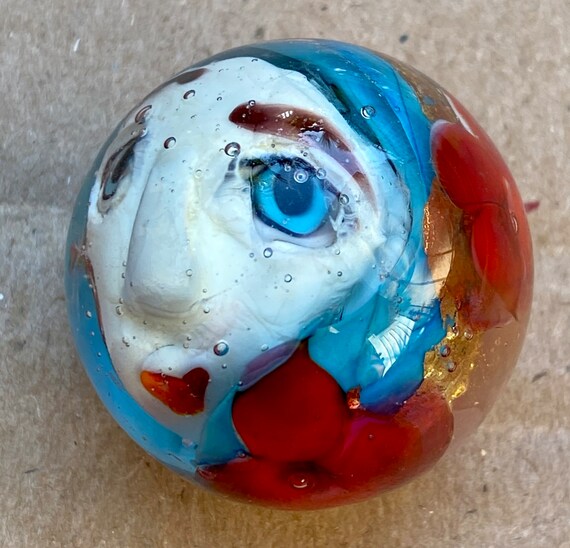 Handmade artisan glass collector's marble head Leslie, with 23 KT gold foil hair and red flowers.