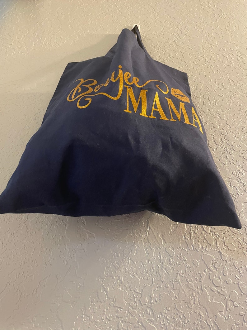 May include: A navy blue tote bag with gold lettering that says "Boojee Mama" with a gold lip print.