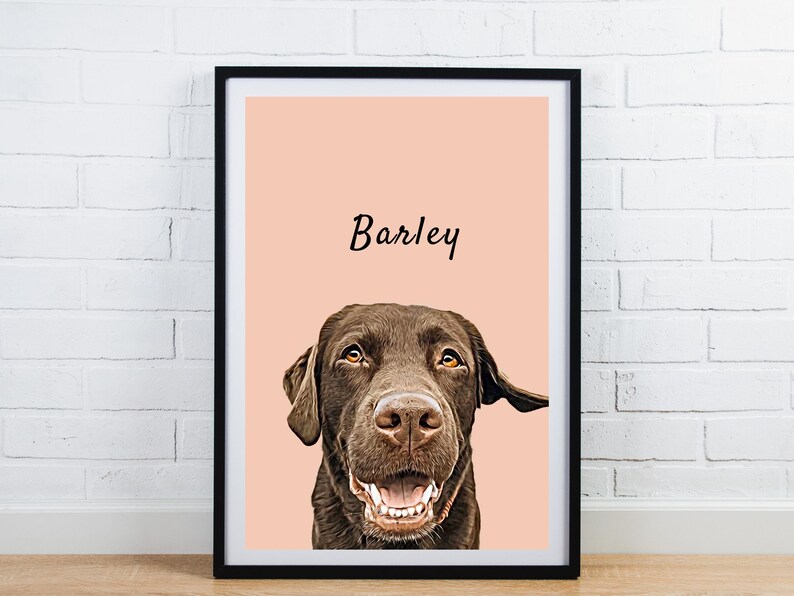 May include: Framed portrait of a chocolate Labrador Retriever named Barley. The dog's head and shoulders are centered against a peach background. The dog is smiling, showing its teeth. The name "Barley" is written in cursive above the dog's head. The frame is black.