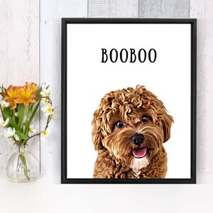 May include: A framed print of a brown and white dog with curly hair. The dog is looking at the camera and has its tongue sticking out. The print has the word "BOOBOO" written in black text at the top.
