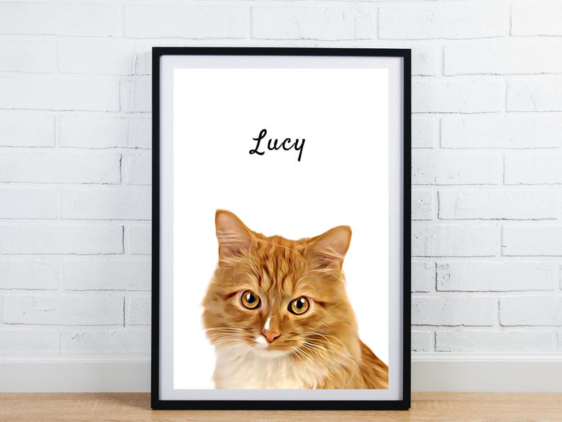 May include: Framed print featuring a close-up of an orange tabby cat with yellow eyes and white markings. The cat's name, "Lucy", is written in cursive above the image. The print is in a black frame and set against a white background.