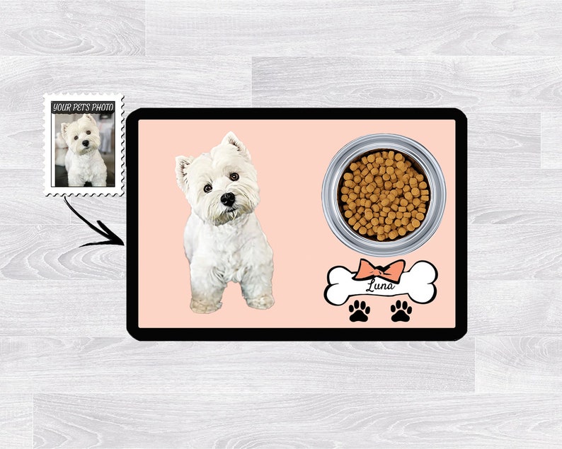 Pu&ograve; includere: Un tappetino per cibo per cani rosa e bianco con un'etichetta a forma di osso con il nome "Luna". Il tappetino presenta un'immagine di un cane bianco e una ciotola di cibo per cani.
