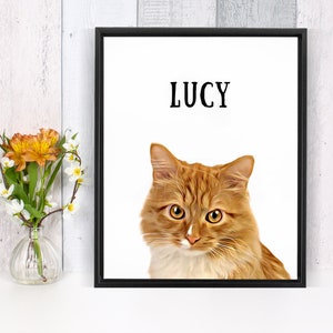 May include: A framed print of a ginger cat with white fur on its chest and paws. The cat is looking directly at the viewer. The name "LUCY" is printed in black at the top of the print.