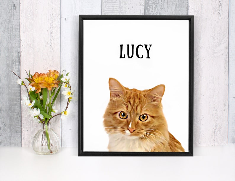 May include: A framed print of a ginger cat with white fur on its chest and paws. The cat is looking directly at the viewer. The name "LUCY" is printed in black at the top of the print.