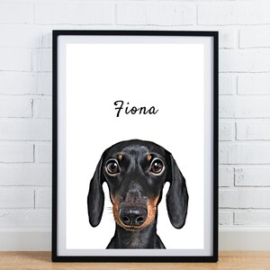 May include: Framed print featuring a black and tan dachshund dog with the name "Fiona" in script above the dog's head. The dog's eyes are brown, and the frame is black. The background is white.