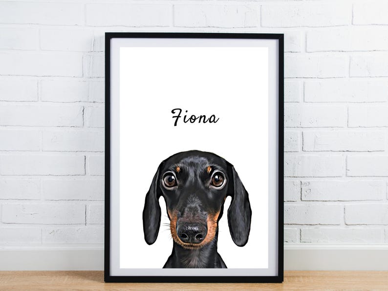 May include: Framed print featuring a black and tan dachshund dog with the name "Fiona" in script above the dog's head. The dog's eyes are brown, and the frame is black. The background is white.