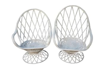 May include: A pair of white wicker swivel chairs with a diamond pattern. The chairs have a round base and are perfect for a patio or garden.