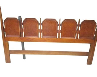 May include: A wooden headboard with a geometric design. The headboard is made of wood with a light brown finish. The headboard has a rectangular shape and is supported by two vertical posts.