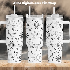 May include: A white 40oz tumbler with a black and white pattern of cowboy hats, bull skulls, playing cards, and geometric designs. The tumbler has a handle and a lid with a straw.