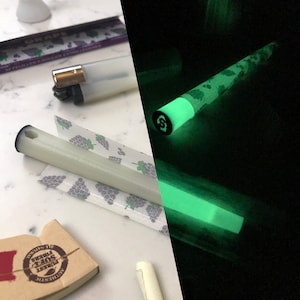 May include: A white and green glow-in-the-dark rolling paper with a grape design and the text "GRAPES 50 feuilles a rouler extra longues".