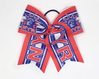 Op de afbeelding: Rode, witte en blauwe cheer bow met de letters "NYR" en een afbeelding van het Vrijheidsbeeld.