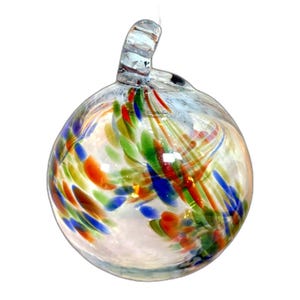 May include: A clear glass ornament with a loop at the top. The ornament is round and filled with colorful streaks of orange, green, blue, and red. The glass has a smooth, glossy finish.