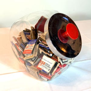 Tarro de cristal antiguo para mostrador, tapa cromada, pomo rojo, colección de cajas de cerillas (años 40-80).
