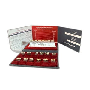 May include: A dental shade guide kit with multiple rows of teeth samples and a color selection guide. The kit includes a Vivastar shade guide and a red velvet display case. The text on the guide reads "Blend Analysis" and "Suggested Anterior-Posterior Blend-Shade Combinations."
