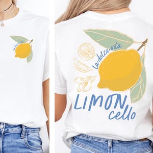 K&ouml;nnte beinhalten: Wei&szlig;es T-Shirt mit einem gelben Zitronen-Design und gr&uuml;nen Bl&auml;ttern, mit den Aufschriften "la dolce vita" und "Limoncello". Das Design ist auf der Vorder- und R&uuml;ckseite. L&auml;ssiger Stil.