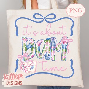 May include: Cream-colored tote bag with the phrase "it's about BAM time" in pink and floral print. The design includes a blue frame with a bow and pink accents. The bag also features the text "Kalliope DESIGNS".
