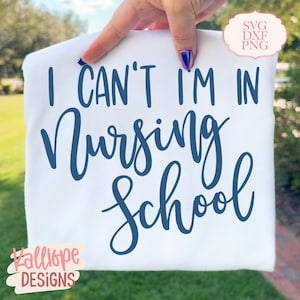 K&ouml;nnte beinhalten: Wei&szlig;es T-Shirt mit dem marineblauen Text "I CAN'T I'M IN Nursing School". Das Shirt zeigt auch den Text "Kalliope Designs" in Rosa und eine kleine Grafik mit der Aufschrift "SVG DXF PNG".