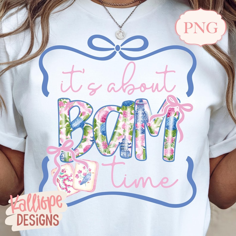 May include: White t-shirt with the phrase "it's about BAM time" in pink script and floral-patterned letters. The design includes a blue bow and a pink tag with a bird illustration. The brand name "Kalliope DESIGNS" is at the bottom.