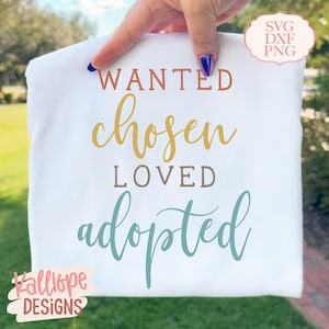May include: A white t-shirt featuring the words "WANTED, chosen, LOVED, adopted" in shades of orange, gold, brown, and teal. The shirt also has the text "SVG DXF PNG" and the logo "Kalliope DESIGNS".