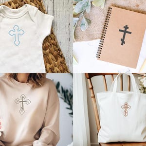 Op de afbeelding: Een verzameling items met een kruisontwerp. Inclusief een witte babyromper met een lichtblauw kruis, een bruin notitieboek met een zwart kruis, een bruin sweatshirt met een kruis en een witte draagtas met een kruis.