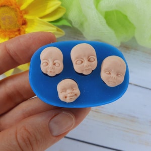 Può includere: Uno stampo in silicone blu con quattro impressioni di facce di bambino. Lo stampo è progettato per creare decorazioni di pasta di zucchero o pasta di gomma per torte.