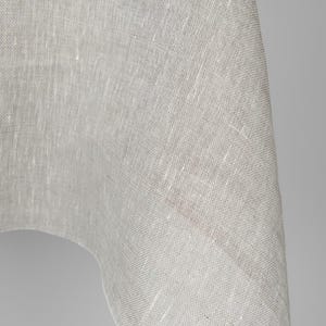 May include: Close-up of a white linen fabric with a textured weave. The fabric is soft and drapes nicely.