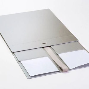 May include: A silver gift box with a ribbon closure and four compartments. The box is open and the compartments are empty.