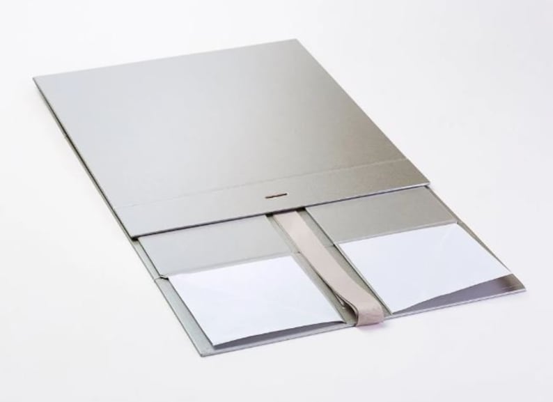 May include: A silver gift box with a ribbon closure and four compartments. The box is open and the compartments are empty.