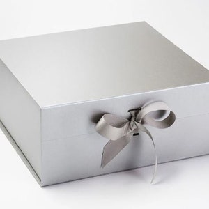 May include: A silver gift box with a satin ribbon tied in a bow. The box is made of sturdy cardboard and has a magnetic closure.