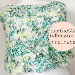 May include: A crocheted shawl in shades of green, white, and yellow. The shawl is made with a delicate stitch pattern and has a scalloped edge. The text "uncinetto istruzioni ITALIANO" is visible on the image.