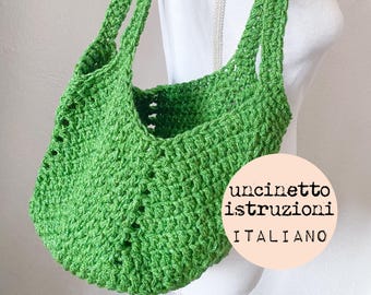 May include: A green crocheted tote bag with a double strap. The bag is made with a simple stitch pattern and has a slightly slouchy shape. The text "uncinetto istruzioni italiano" is written on a pink circle.