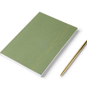 Peut inclure: Un carnet vert avec des lignes dorées sur la couverture et un stylo doré.